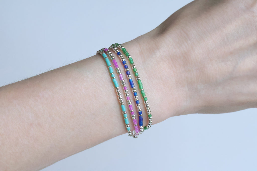 A cluster of beaded Morse code bracelets worn together