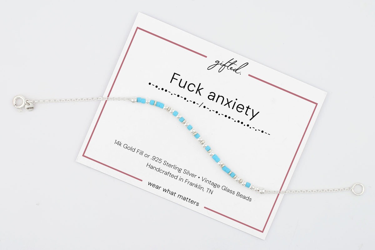Fuck anxiety on its printed gifted. card, with the Morse line and the materials named