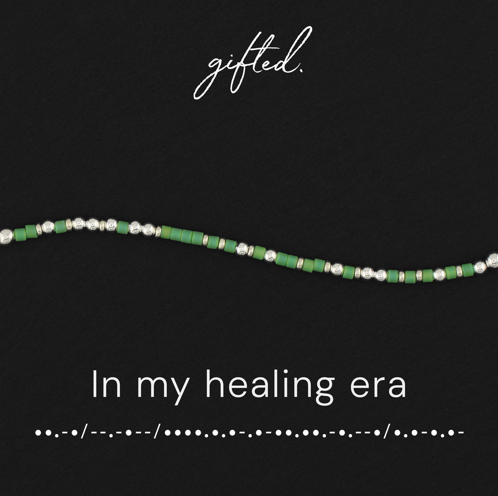 In my healing era spelled in Morse code in glass and metal beads, shown on black