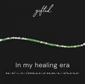 In my healing era spelled in Morse code in glass and metal beads, shown on black