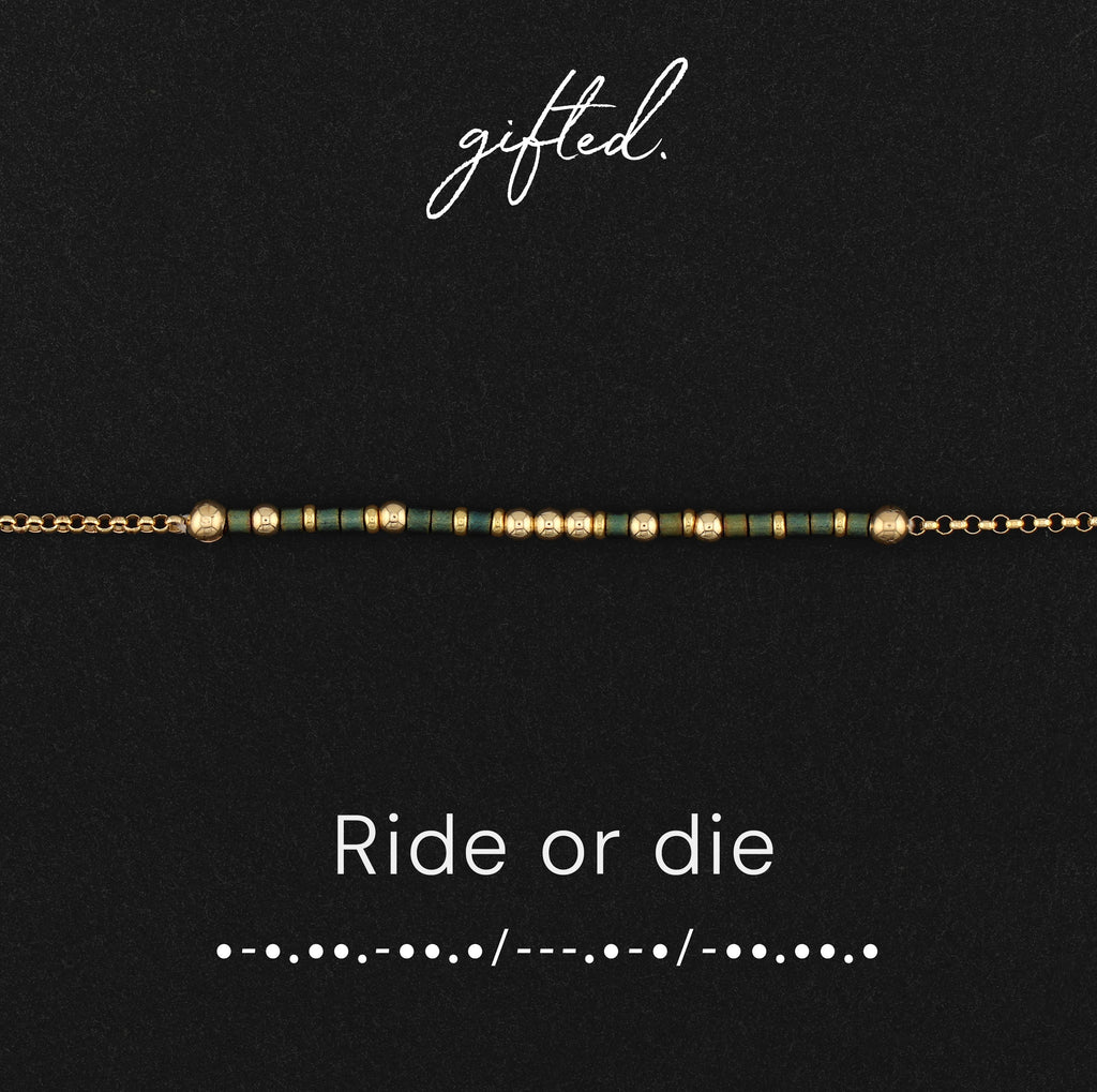 Ride or die spelled in Morse code in glass and metal beads, shown on black