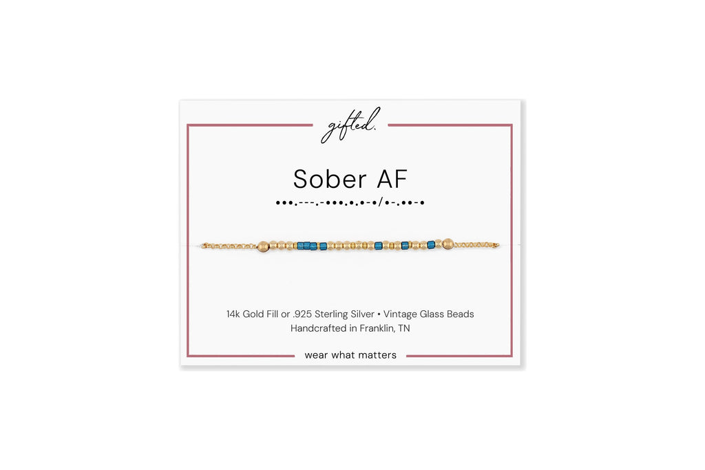 Sober AF spelled in Morse code in glass and metal beads on a gifted. card.