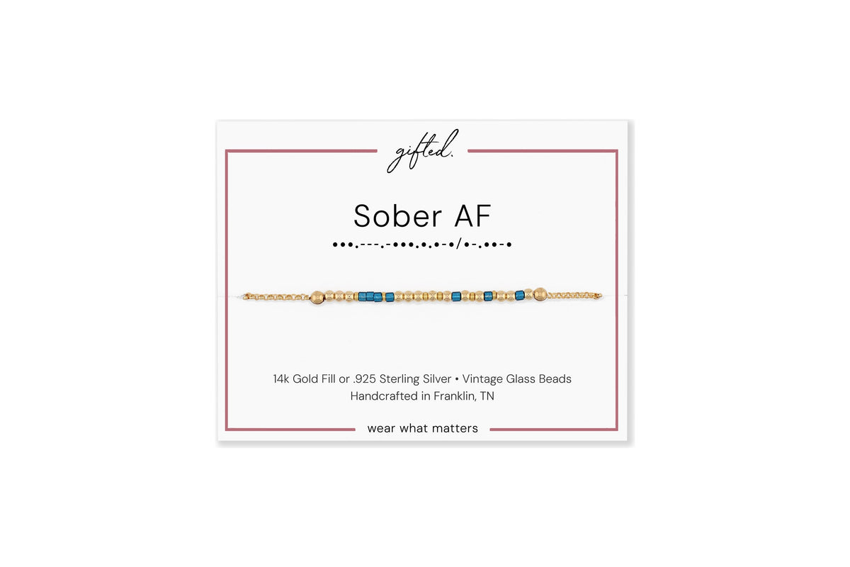 Sober AF spelled in Morse code in glass and metal beads on a gifted. card.