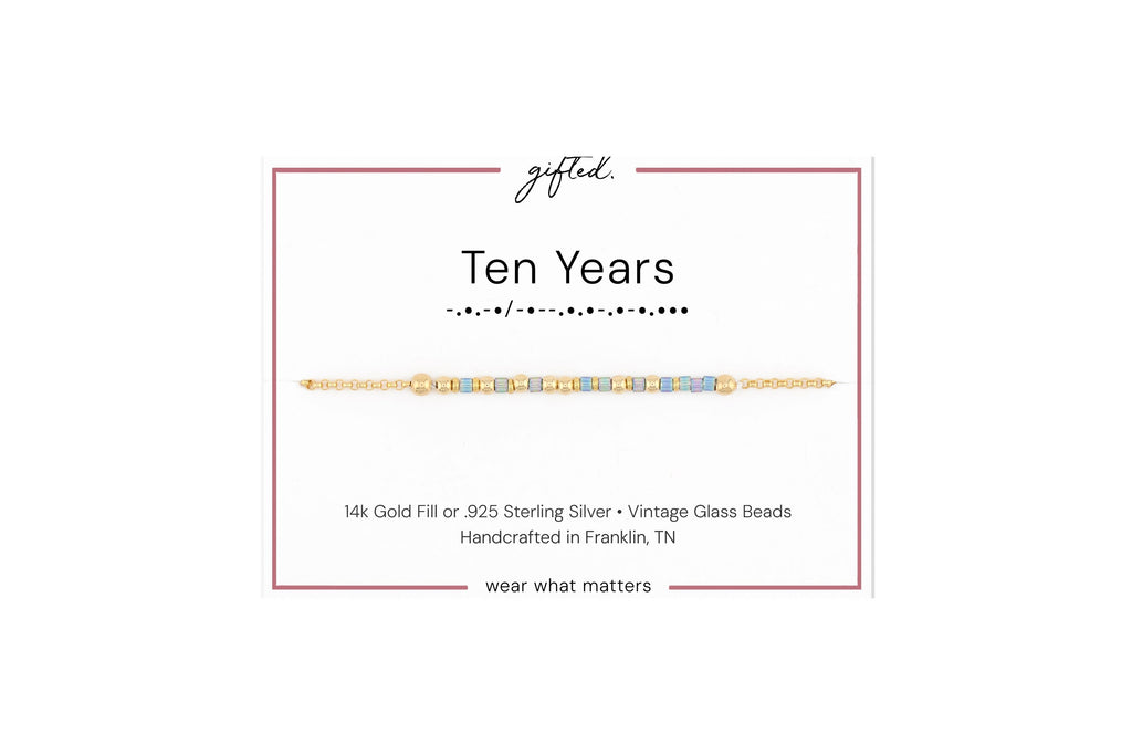 Ten years spelled in Morse code in glass and metal beads on a gifted. card.