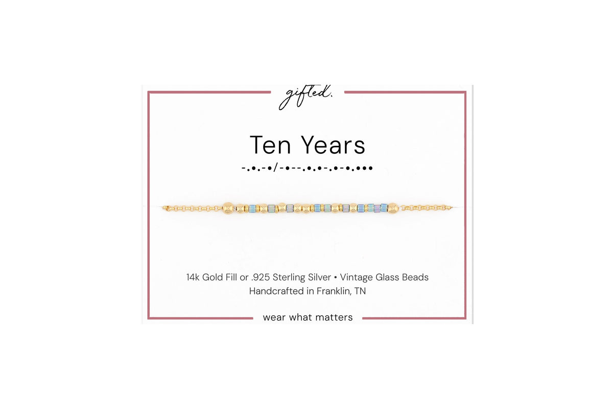 Ten years spelled in Morse code in glass and metal beads on a gifted. card.