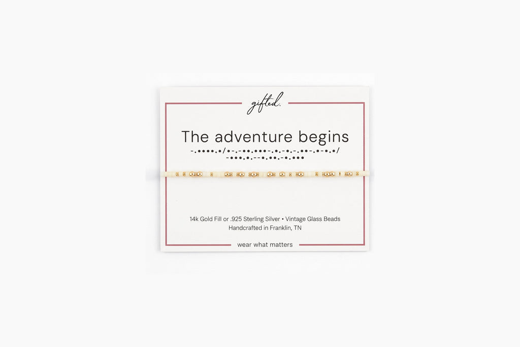 The adventure begins spelled in Morse code in glass and metal beads on a gifted. card.