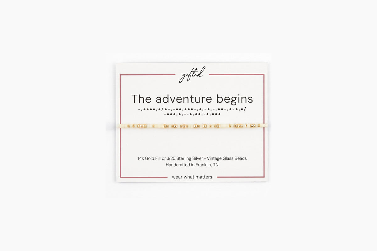 The adventure begins spelled in Morse code in glass and metal beads on a gifted. card.