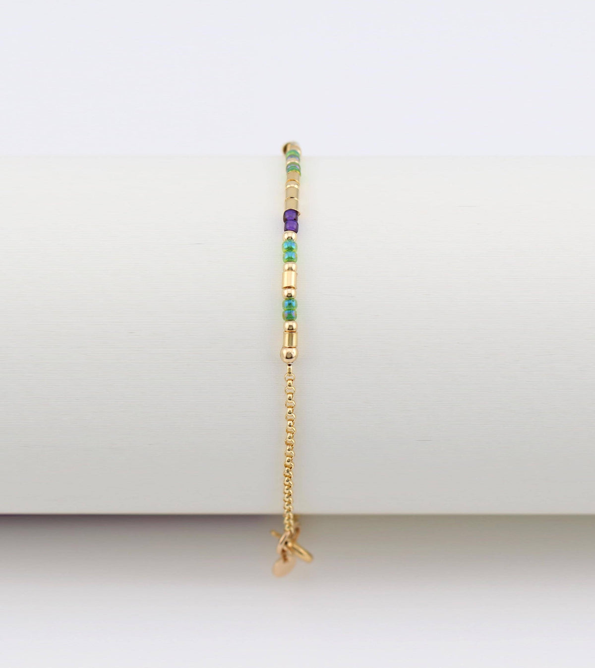 14k gold fill morse code bracelet hanging vertically, showing the gifted. tag charm at the clasp