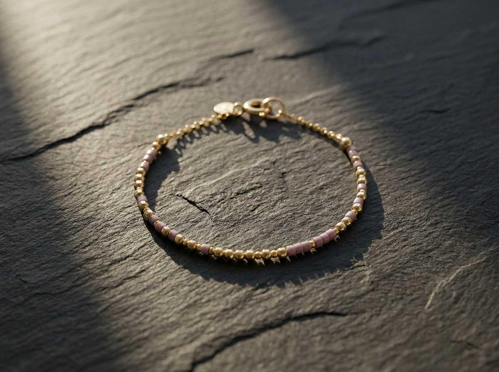 A beaded Morse code bracelet photographed on dark slate