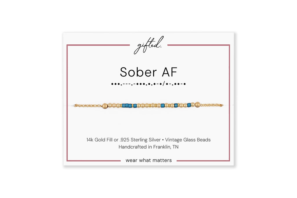 Sober AF spelled in Morse code on a beaded bracelet, shown on its printed gift card
