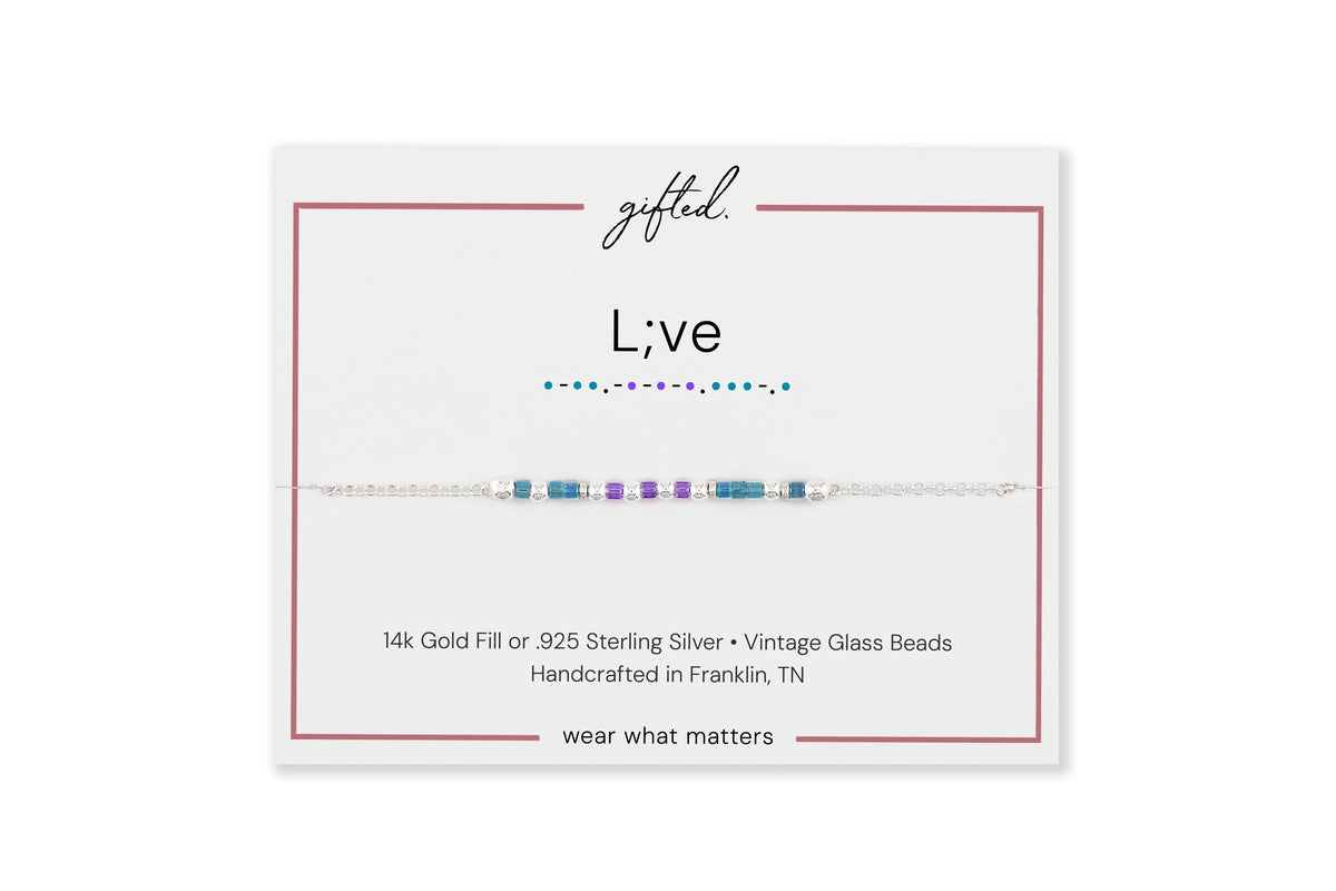 L;ve spelled in Morse code on a beaded bracelet, shown on its printed gift card