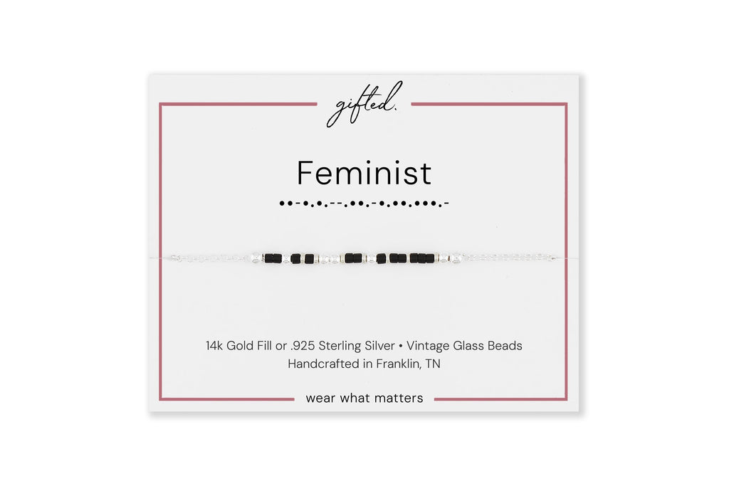 Feminist spelled in Morse code on a beaded bracelet, shown on its printed gift card