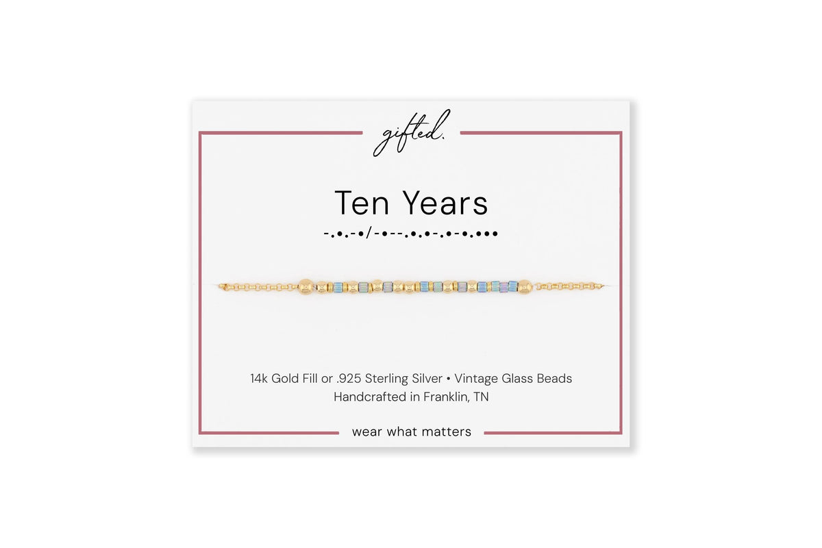 Ten Years spelled in Morse code on a beaded bracelet, shown on its printed gift card