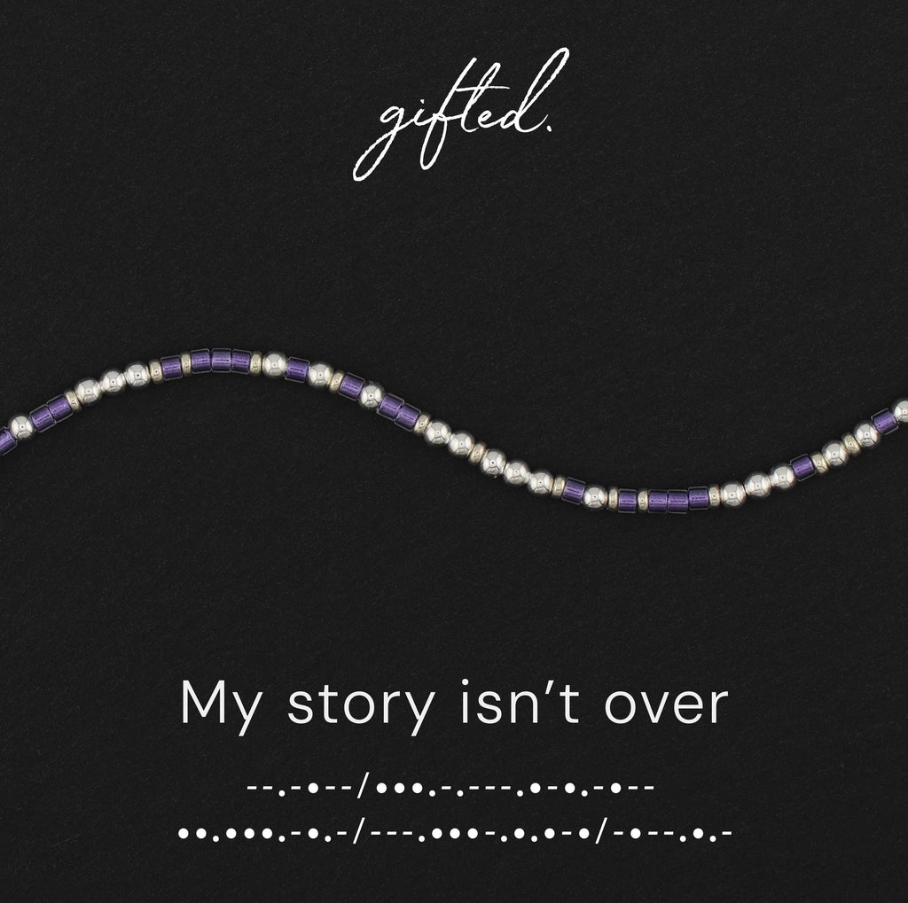 My Story Isn't Over spelled in Morse code in glass and metal beads, shown on black