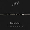 Feminist spelled in Morse code in glass and metal beads, shown on black