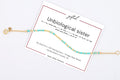 Unbiological sister spelled in Morse code in beads on a gifted. card