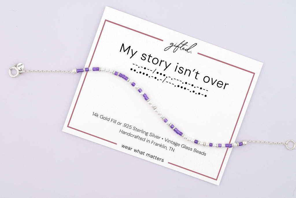 My Story Isn't Over spelled in Morse code on a beaded bracelet, shown on its printed gift card