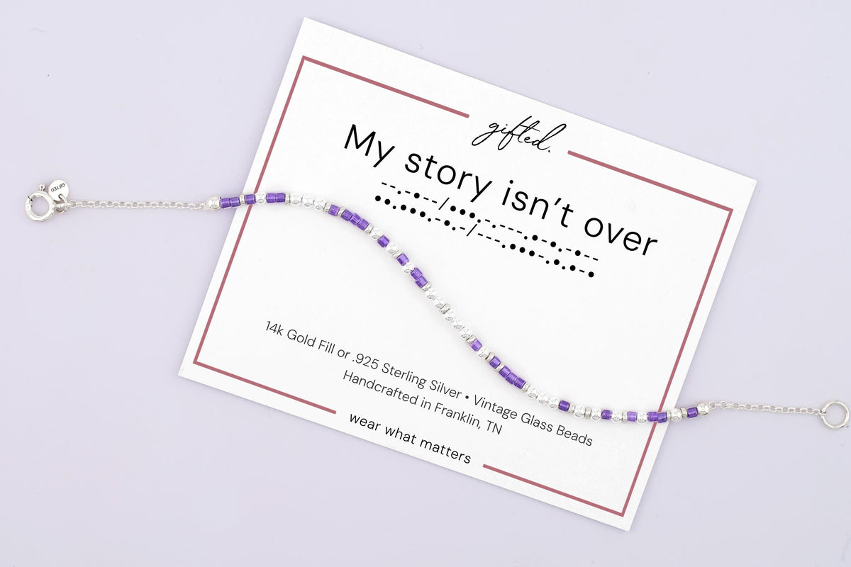 My Story Isn't Over spelled in Morse code on a beaded bracelet, shown on its printed gift card
