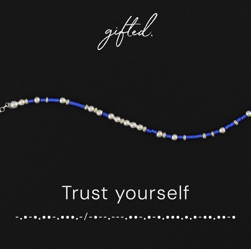 Trust Yourself spelled in Morse code in glass and metal beads, shown on black