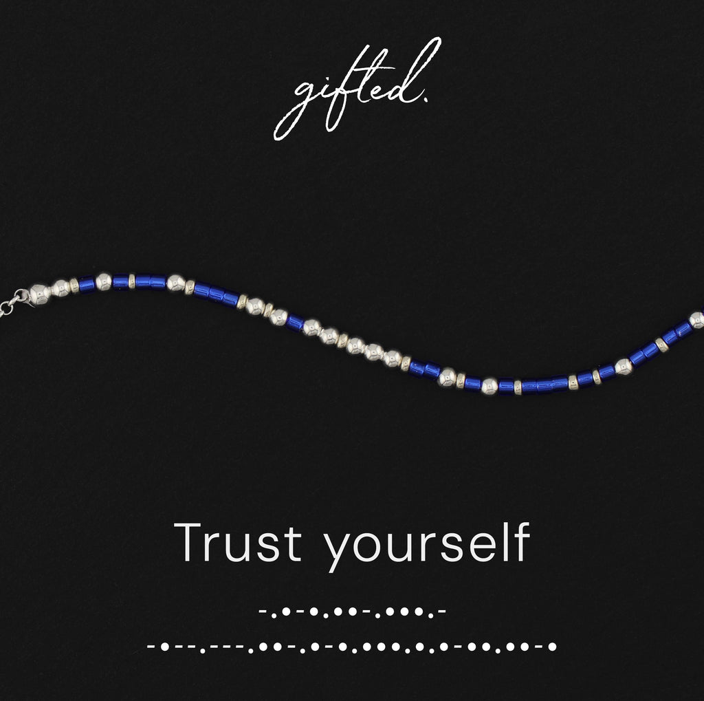 Trust Yourself spelled in Morse code in glass and metal beads, shown on black