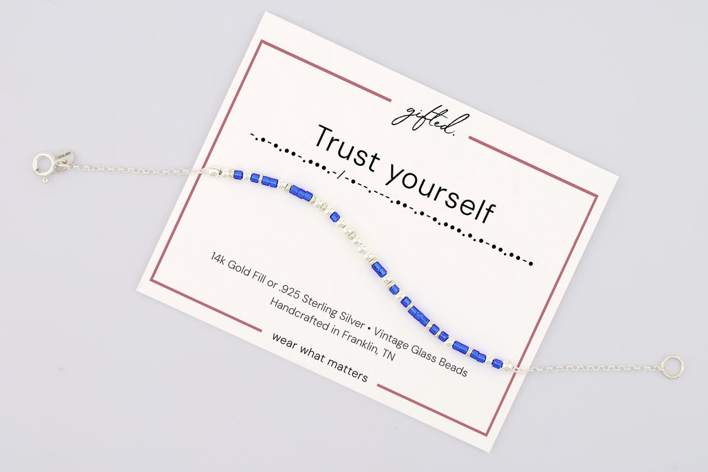Trust Yourself spelled in Morse code on a beaded bracelet, shown on its printed gift card