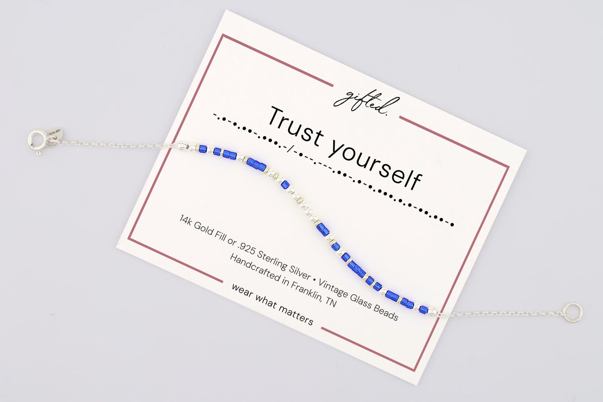 Trust Yourself spelled in Morse code on a beaded bracelet, shown on its printed gift card