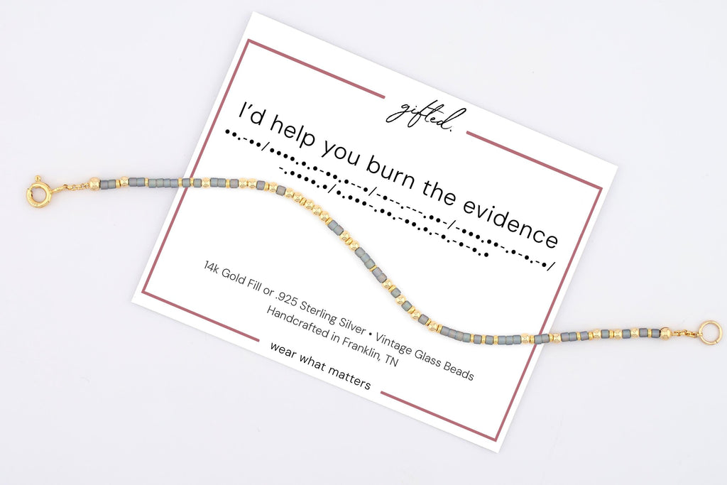 I'd Help You Burn the Evidence spelled in Morse code on a beaded bracelet, shown on its printed gift card